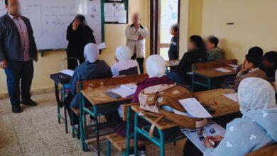 فصلًا دراسيًا في بيئة تعليمية، حيث يظهر معلمون يوجهون الطلاب خلال حصة دراسية